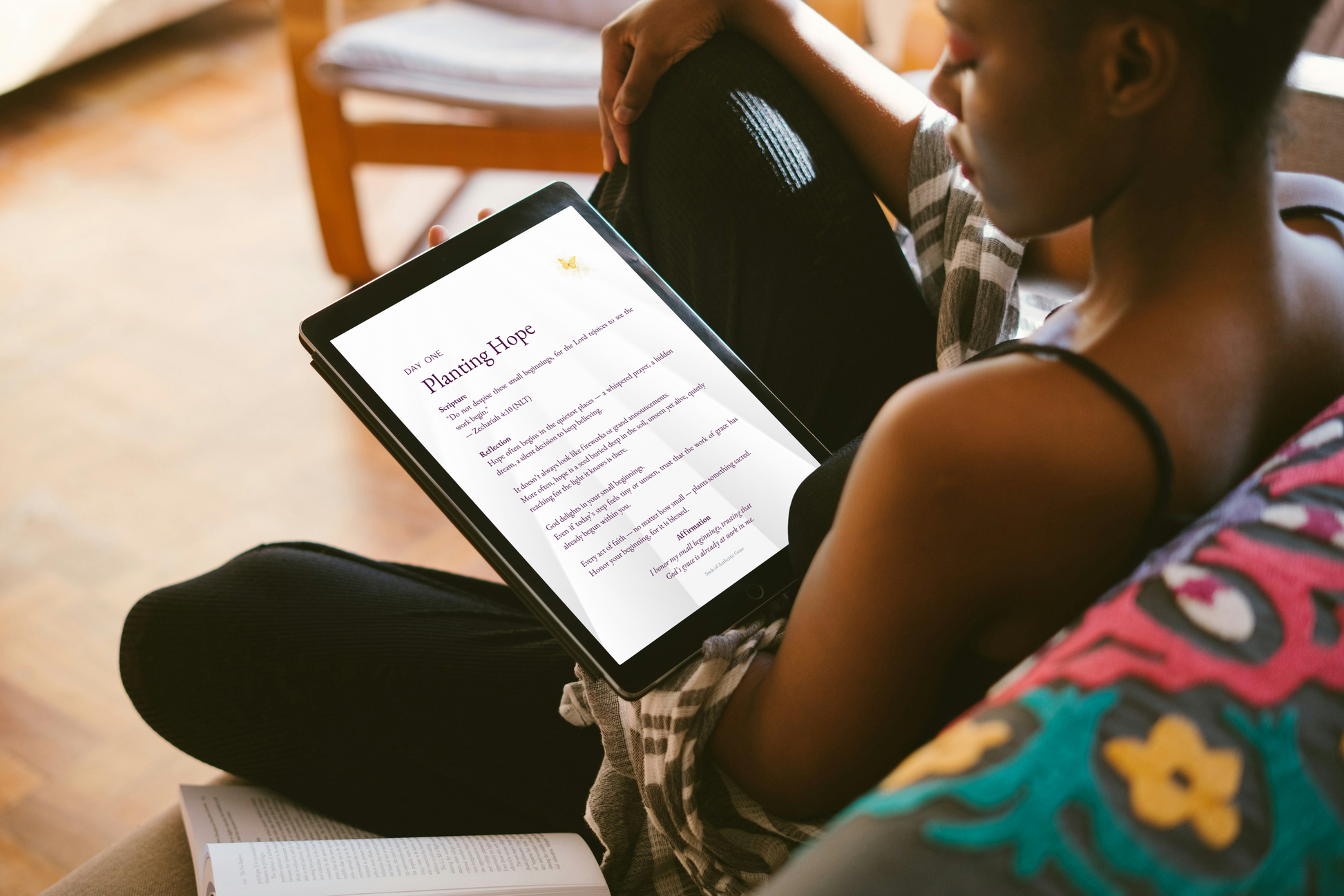 Person sitting on a couch holding a tablet with a document titled 'Planting Hope'.